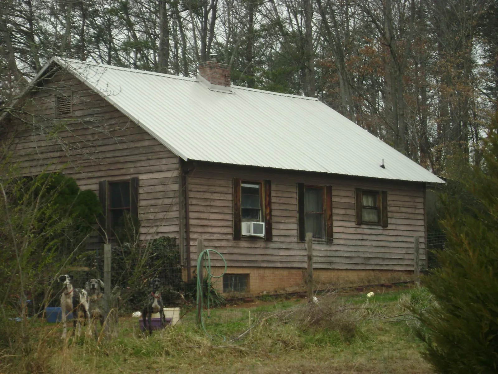 White metal roof on an old wood sided farmhouse, from a Metal Roof Installation job in Winfield